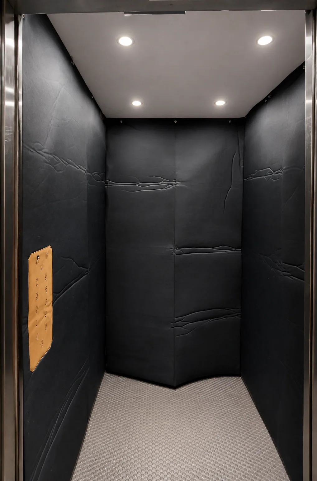 Installation réelle d’une protection noire sur mesure dans une cabine d’ascenseur